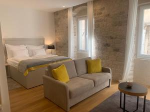 1 dormitorio con 1 cama, 1 sofá y 1 cama en Priuli Luxury Rooms, en Split