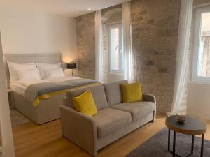 a bedroom with a bed and a couch and a bed at Priuli Luxury Rooms in Split