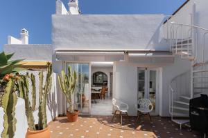 une maison avec un patio avec des chaises et des cactus dans l'établissement MONKÓ VILLA CASABLANCA, à Benalmádena