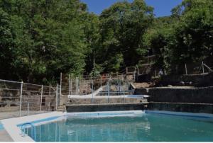 uma piscina de água num parque com árvores em Hostal Cielo de Gredos em Guisando