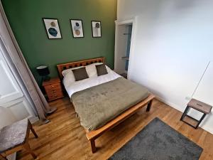 a bedroom with a bed and a green wall at Central Large 2 Bed, 2 Bath Apt, Parking, Huge Garden, SKY TV, Wifi, Direct Booking Option in Exeter