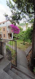 a gate with a house with a sign on it at Vojinovic Apartments in Budva