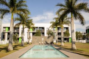 an apartment building with a swimming pool and palm trees at Spacious Modern 2-Bedroom Apartment with Pool & Gym Access in Ballito