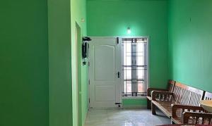 um quarto verde com uma porta e uma janela em FabExpress MK Homes em Kodaikanal