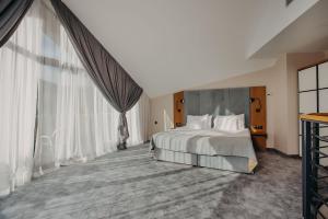 カルパチにあるGreen Mountain 5* Hotelのベッドルーム(大きなベッド1台、大きな窓付)