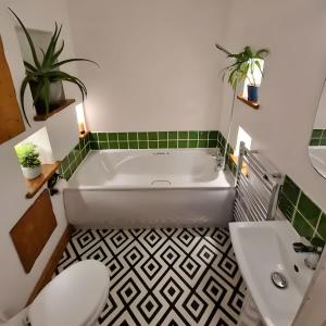 a bathroom with a tub and a toilet and a sink at Central Large 2 Bed, 2 Bath Apt, Parking, Huge Garden, SKY TV, Wifi, Direct Booking Option in Exeter