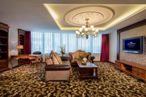 a living room with a couch and a table at Howard Johnson Paragon Hotel Beijing Central in Beijing