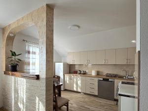 an open kitchen with white cabinets and a table at Apartman Ćalasan in Plužine