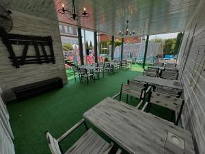 an empty restaurant with wooden tables and chairs at Viktoriya Family 2 Country complex in Kyiv