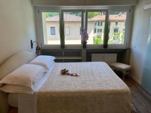 a bedroom with a bed and a window with flowers on it at Varenna Guest House in Varenna