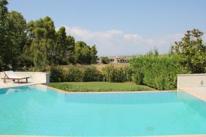 a large swimming pool with a table and a bench at Serenity Villa in Sani in Sani Beach