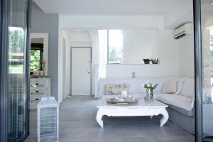 a living room with a white couch and a table at Serenity Villa in Sani in Sani Beach