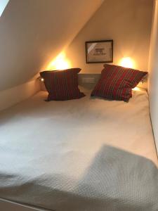 una camera da letto con 2 cuscini a righe su un letto di Appartement Wattsein a Morsum