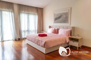 a bedroom with a large bed with a red pillow on it at Damansara Heights by Plush in Kuala Lumpur