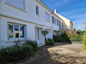 a white house with a driveway in front of it at Maison 6 chambres Saint Nazaire 5 min de la mer in Saint-Nazaire