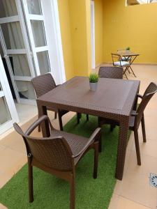 a wooden table and chairs on a green rug at Apartamentos ORLANDO en Costa Adeje in Adeje