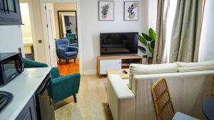 a living room with a couch and chairs and a television at Apartamentos Puente Romano Suites Parking Gratis in Merida