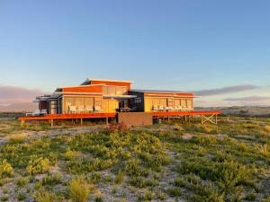 a house in the middle of a field at Walkerbay Dunes Lodge in Stanford