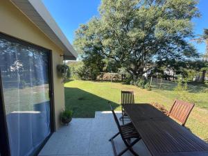 a patio with a wooden table and two chairs at PINE COTTAGE Self catering fully equipped 2 bedroom, Queen bed 3 singles 65sqm cosy private cottage in Durban