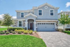 a large white house with a garage at 8BR Luxury - Sleeps 22 - Near Disney with Pool & Hot Tub! in Davenport