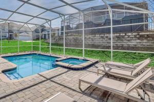una piscina con sillas y una pérgola en 8BR Luxury - Sleeps 22 - Near Disney with Pool & Hot Tub!, en Davenport