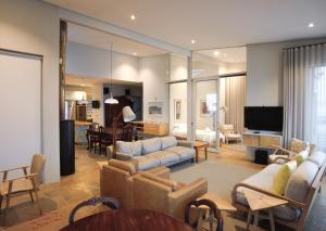 a living room with couches and a dining room at Bokkombaai in Bloubergstrand
