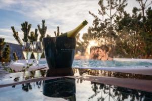 un grupo de personas en una piscina con una botella de vino en Cocoon Deluxe - Luxury Chalet en Chamois