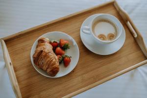 een dienblad met een kopje koffie en een croissant en aardbeien bij GOŚCINA u MARYNY Sauna & Balia in Poronin