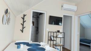 Un comedor blanco con una mesa y sillas. en Elizabeth Apartman Balatonfenyves II., en Balatonfenyves