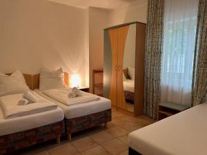 um quarto de hotel com duas camas e um espelho em Gabi mit Pool und Sauna em Übersee