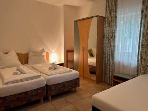 a hotel room with two beds and a mirror at Gabi mit Pool und Sauna in Übersee