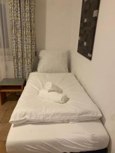 Una cama blanca con una toalla encima. en Gabi mit Pool und Sauna, en Übersee