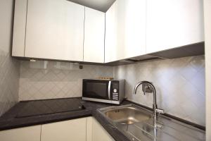 a kitchen with a sink and a microwave at Testaccio View Holiday House in Rome +7 photos