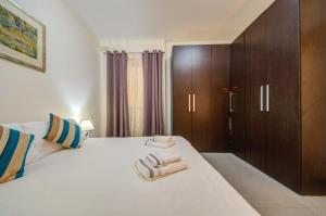 a bedroom with a large bed with towels on it at Sliema 2 Bedroom close to seafront in Sliema