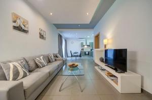 a living room with a couch and a flat screen tv at Sliema 2 Bedroom close to seafront in Sliema