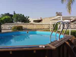 a swimming pool with a wooden bench next to it at Casa Alba by My Home Apulia in Torre Lapillo