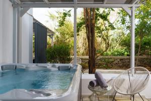 a hot tub on a patio with a table and chairs at Mr and Mrs White Paros in Naousa