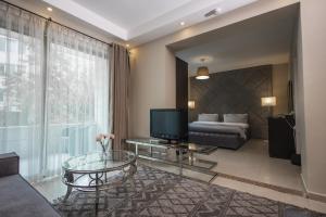 een woonkamer met een televisie en een bank bij Ankars Suites & Hotel in Ramallah