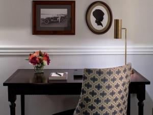 uma secretária com um vaso de flores e uma cadeira em Hotel Viking em Newport