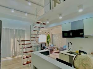 a kitchen and living room with a spiral staircase at Otravel Hostel 5 minutes from Mactan Airport in Pusok