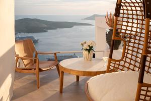 a room with a table and a vase of flowers at CASA SUNSHA SANTORINI in Fira