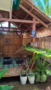 a group of potted plants sitting under a roof at Bella's Bed & Breakfast in Dauis