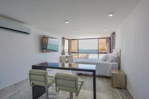 a bedroom with a bed and a table and chairs at Lujoso apartamento con vista al mar in Cartagena de Indias