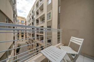 2 sillas blancas sentadas en un balcón en un apartamento en Sliema 2 Bedroom close to seafront en Sliema