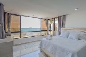 a bedroom with a white bed with a view of the ocean at Lujoso apartamento con vista al mar in Cartagena de Indias