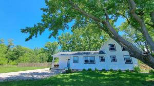a white house with a tree in front of it at Meadow Sunrise in Bridgman