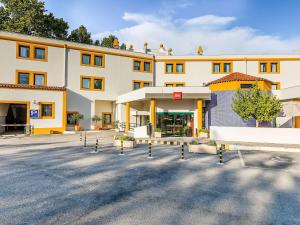 ein großes Gebäude mit einem Parkplatz davor in der Unterkunft Hotel ibis Evora in Évora