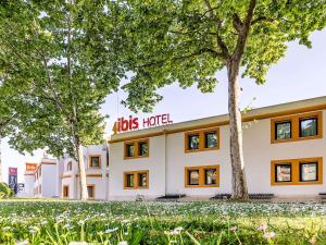 un hôtel avec des arbres devant lui dans l'établissement Hotel ibis Evora, à Évora