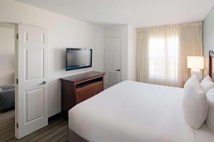 a bedroom with a white bed and a television at Hyatt House Herndon/Reston in Herndon +54 photos