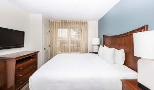 a hotel room with a bed and a television at Hyatt House Herndon/Reston in Herndon